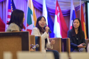 Three women in a panel discussion on a stage