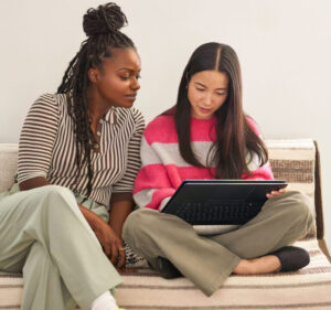 two girls looking at a laptop